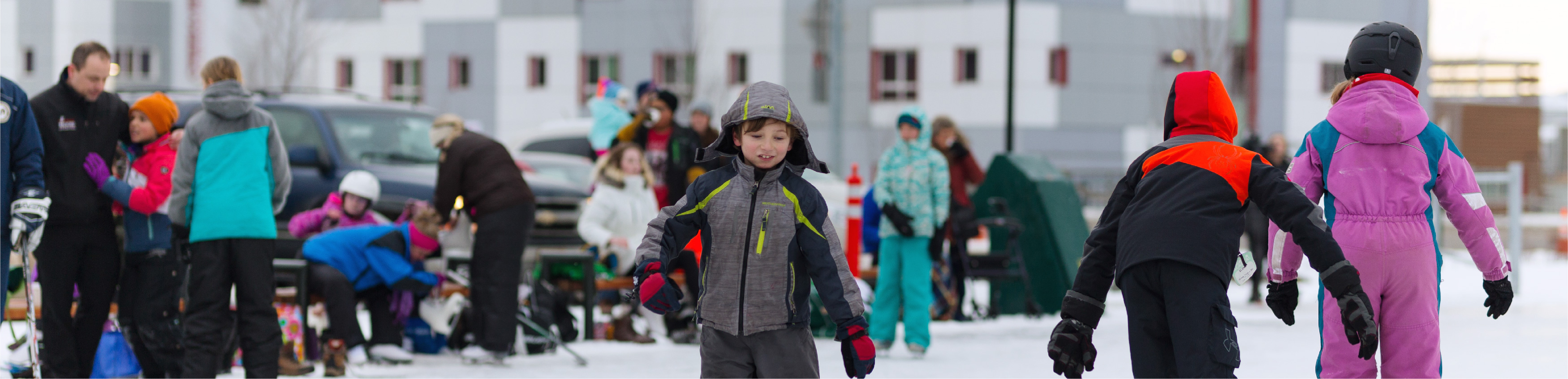 Children ice skating around an ice skating oval